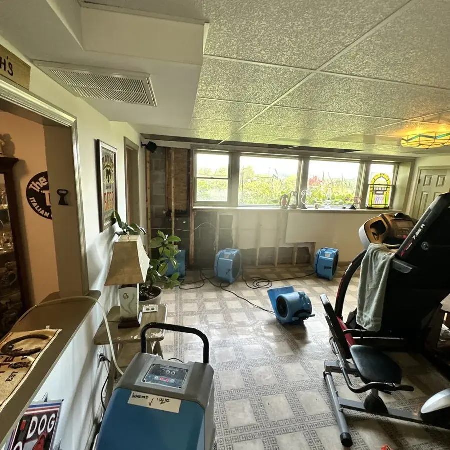 Dehumidifier and air movers drying a sunlit family room