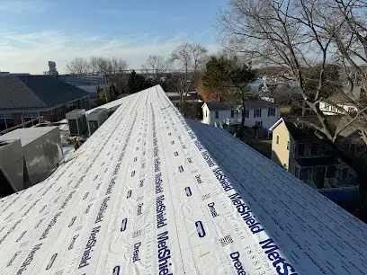 Roof deck covered in new synthetic underlayment along the ridge
